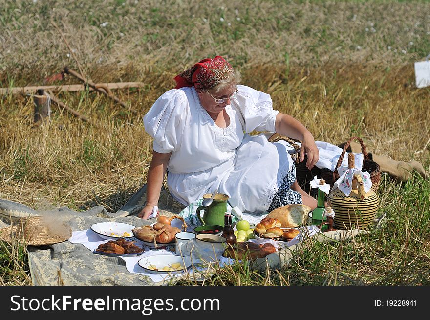 Traditional breakfast in a field at the time of harvest. Hungarian folk costume. Traditional breakfast in a field at the time of harvest. Hungarian folk costume