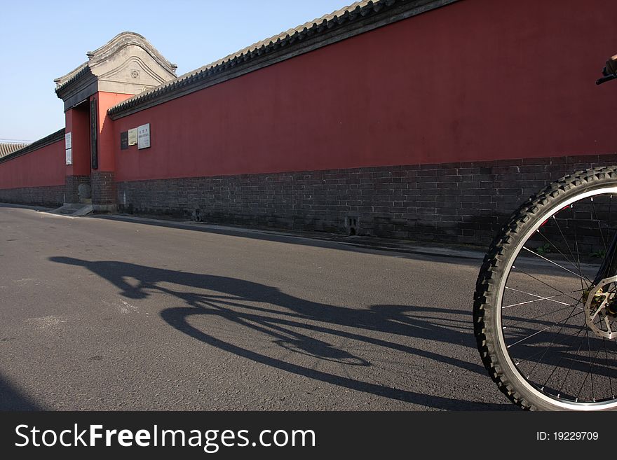 Riding bicycle along the red wall in the morning