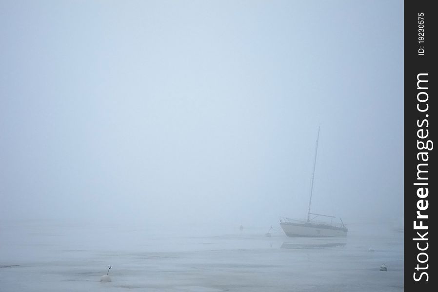 Sailing boat in milky fog