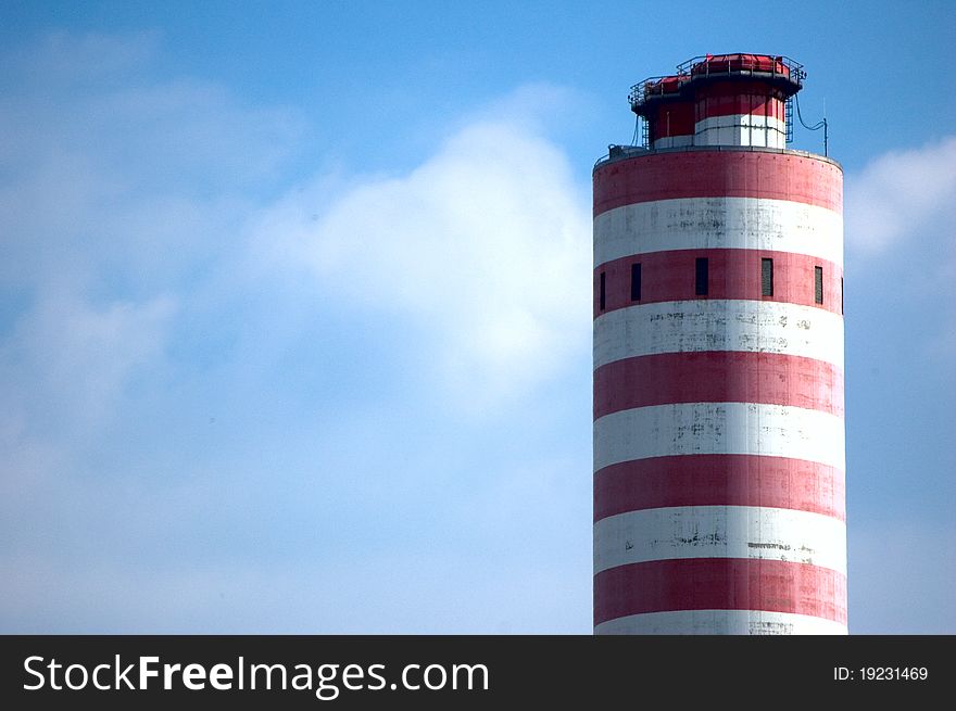 Smokestack of power house against blue sky