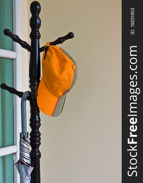 Hanging of orange cap on wooden hanger