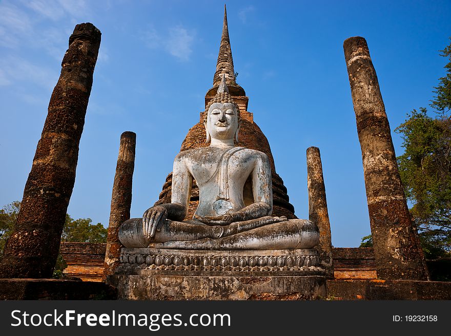 Seated buddha and brick stupa amidst the ruins of an ancient temple in Sukhothai Historical Park, Thailand. Asia. Seated buddha and brick stupa amidst the ruins of an ancient temple in Sukhothai Historical Park, Thailand. Asia.