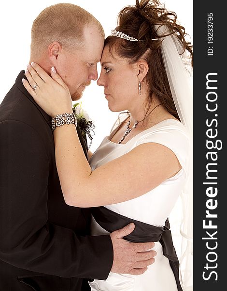 A bride and groom with their heads together looking into each others eyes. A bride and groom with their heads together looking into each others eyes.