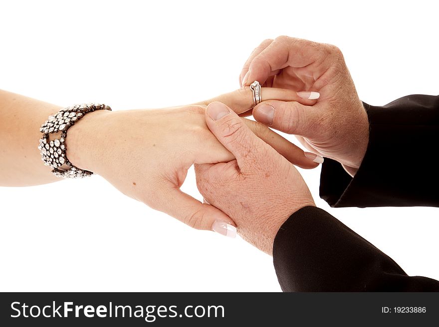 A close up of a groom giving his bride her wedding ring. A close up of a groom giving his bride her wedding ring.