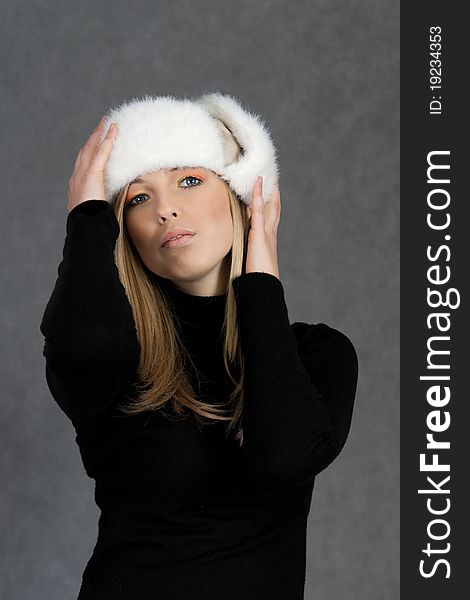 Woman in winter hat on gray background