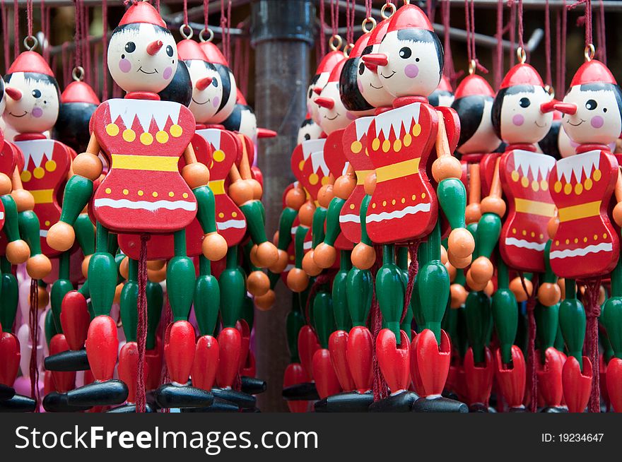 Images shows a bundle of some colourful wooden puppets. Colours dominating the picture are red and green.