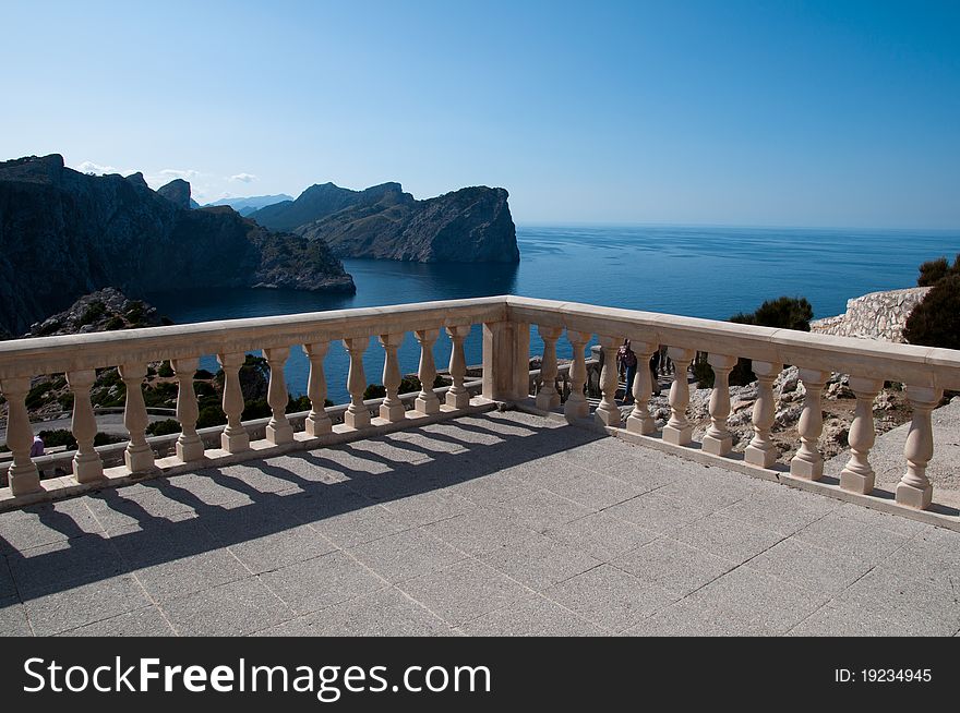 Image shows a scenery of Formentor, Majorca, Spain. A stone view point in the middle, steel coast on the left and blue sea on the right. Above blue sky. Image shows a scenery of Formentor, Majorca, Spain. A stone view point in the middle, steel coast on the left and blue sea on the right. Above blue sky.