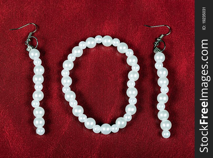 Bracelet and earrings of pearls on red cloth. Bracelet and earrings of pearls on red cloth