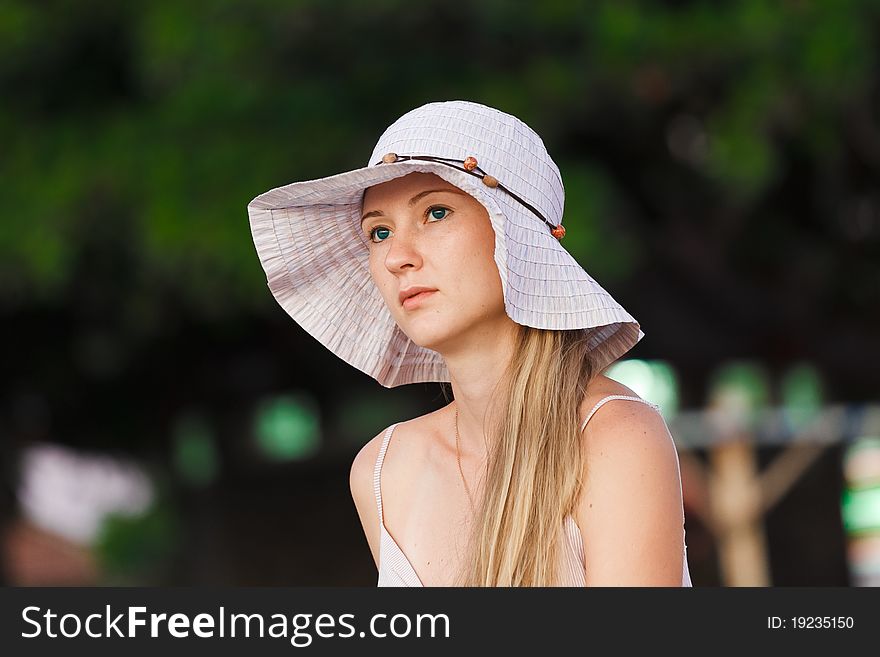 Portrait of a beautiful woman in hat on the beach