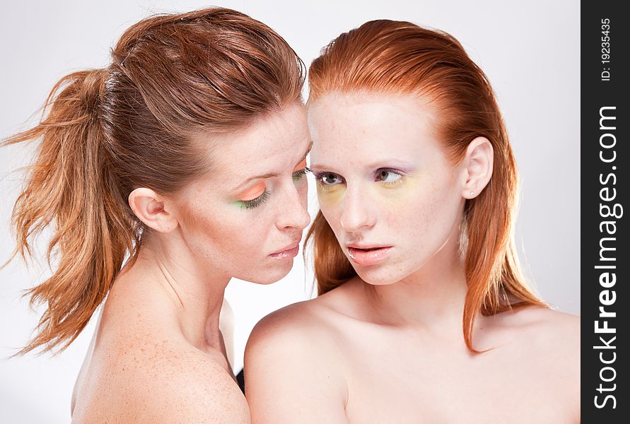 Two red-haired beautiful woman sensually look at each other