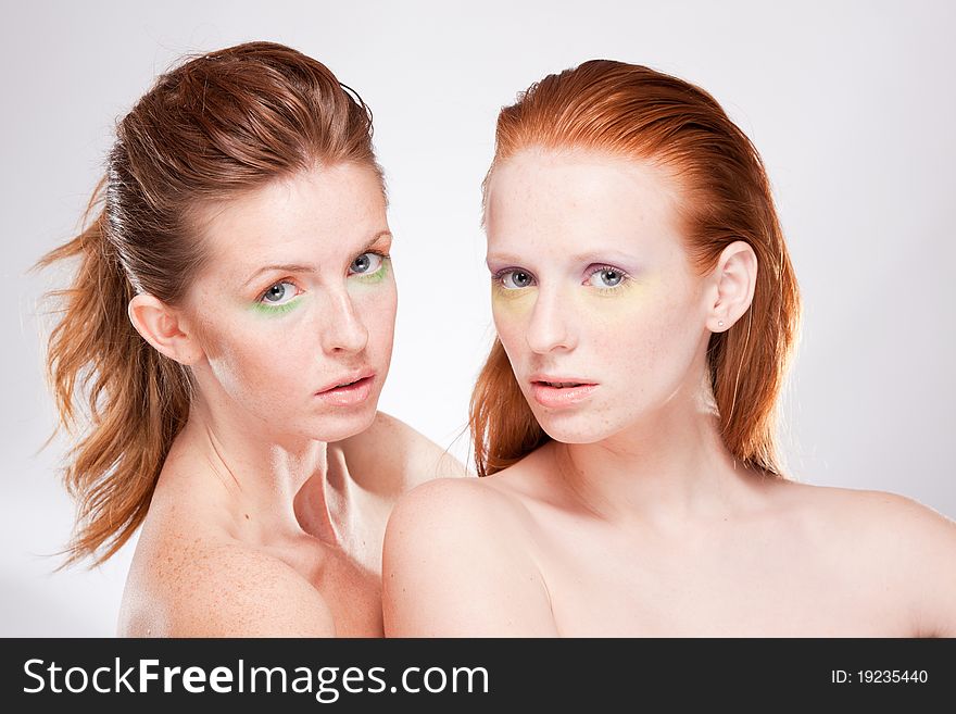 Two red-haired beautiful woman looking at camera