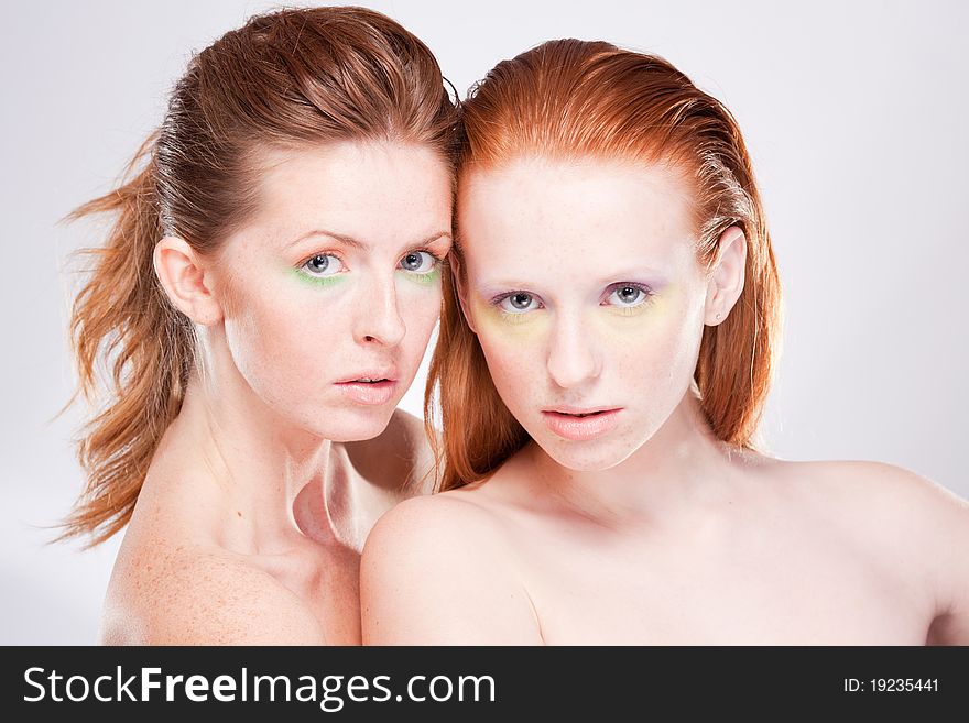 Two red-haired beautiful woman looking at camera