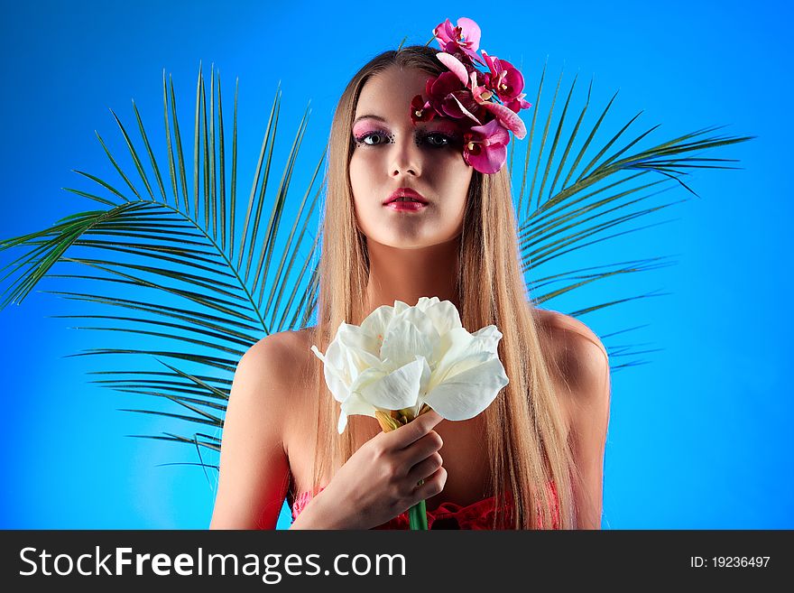 Portrait of a beautiful tanned woman in bikini posing with flowers. Portrait of a beautiful tanned woman in bikini posing with flowers.