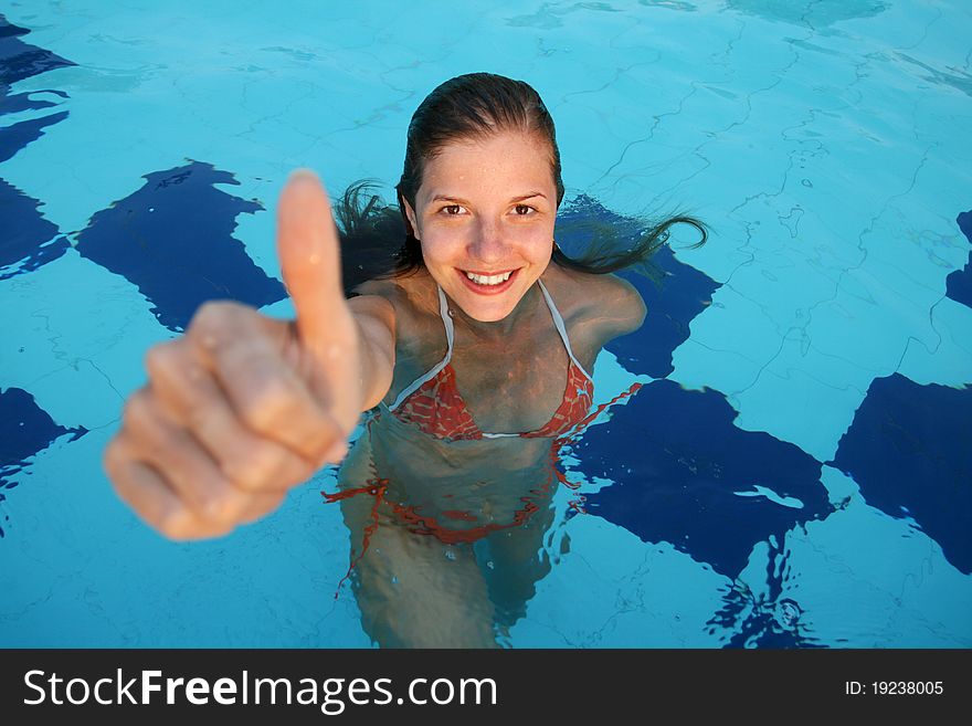 Woman in swimming pool with big thumb up. Woman in swimming pool with big thumb up