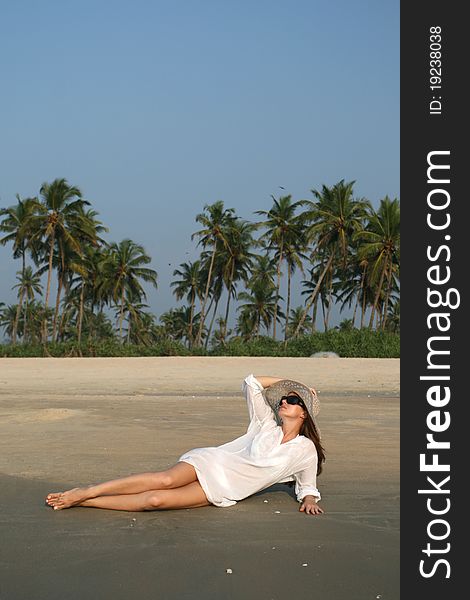 Woman in white hat lying on the beach in tropical country. Woman in white hat lying on the beach in tropical country