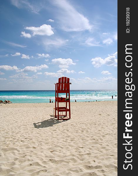 Red lifeguard chair on sandy beach