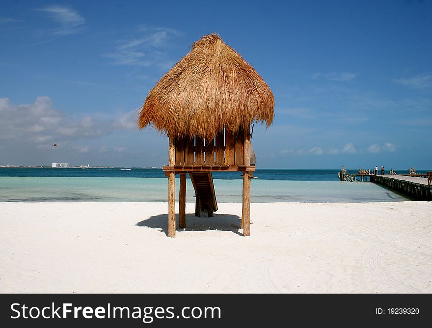 Thatched roof beach hut on white sand beach