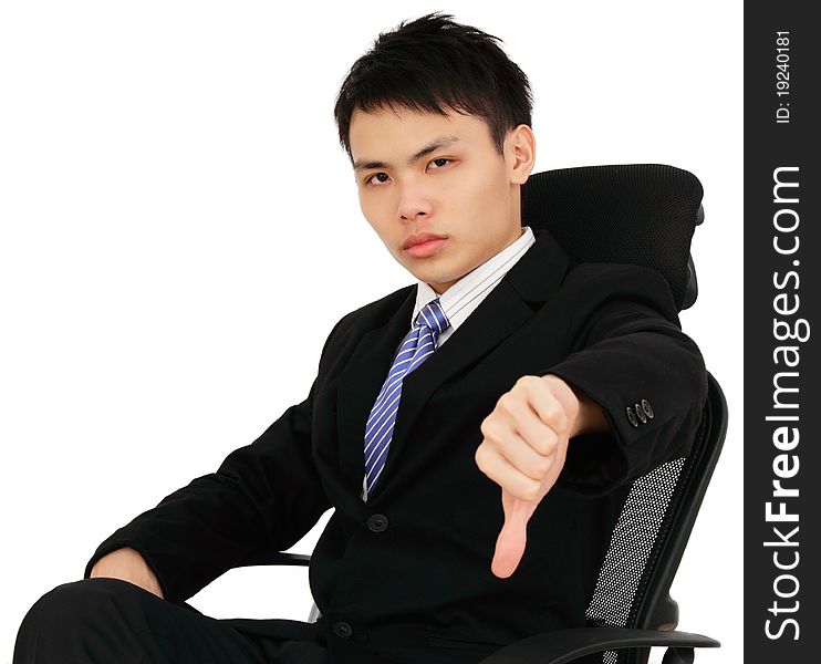 An executive showing thumbs down while sitting on a chair. An executive showing thumbs down while sitting on a chair