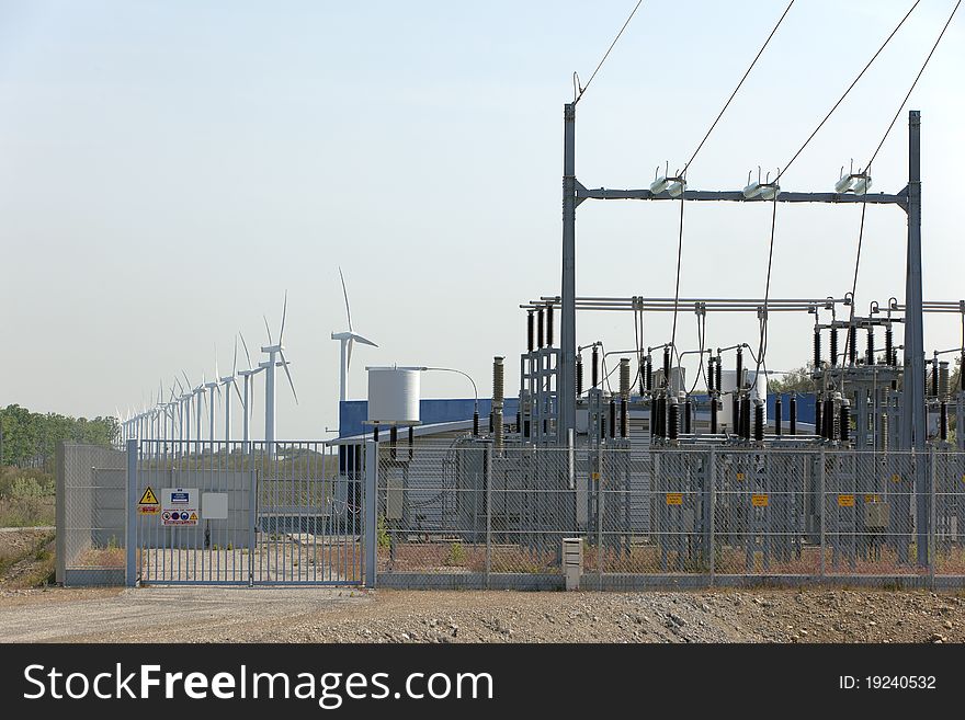 Wind turbines aligned next to power transformer. Wind turbines aligned next to power transformer