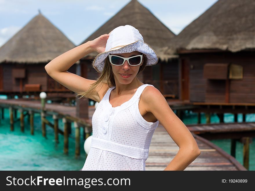 A girl is in white on a pier. A girl is in white on a pier