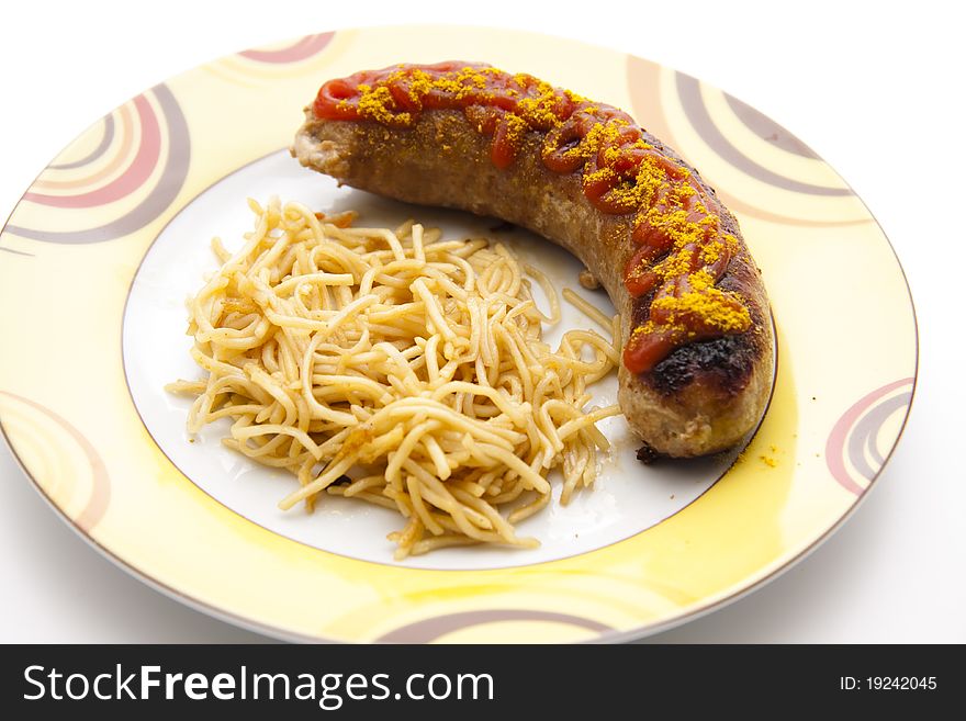 Curry sausage with noodles on ceramics plate