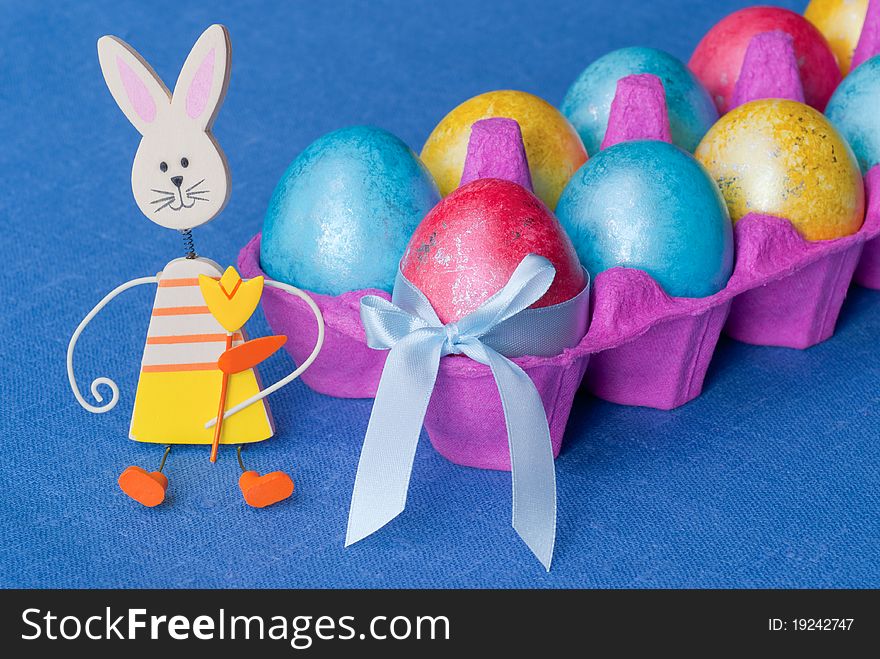 Easter: box with multicolored eggs and funny bunny. Easter: box with multicolored eggs and funny bunny.
