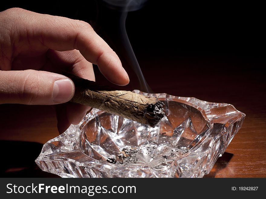 Smoking cigar from cuba over black background