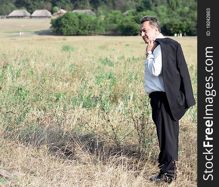 Man with suite stands in the field. Man with suite stands in the field