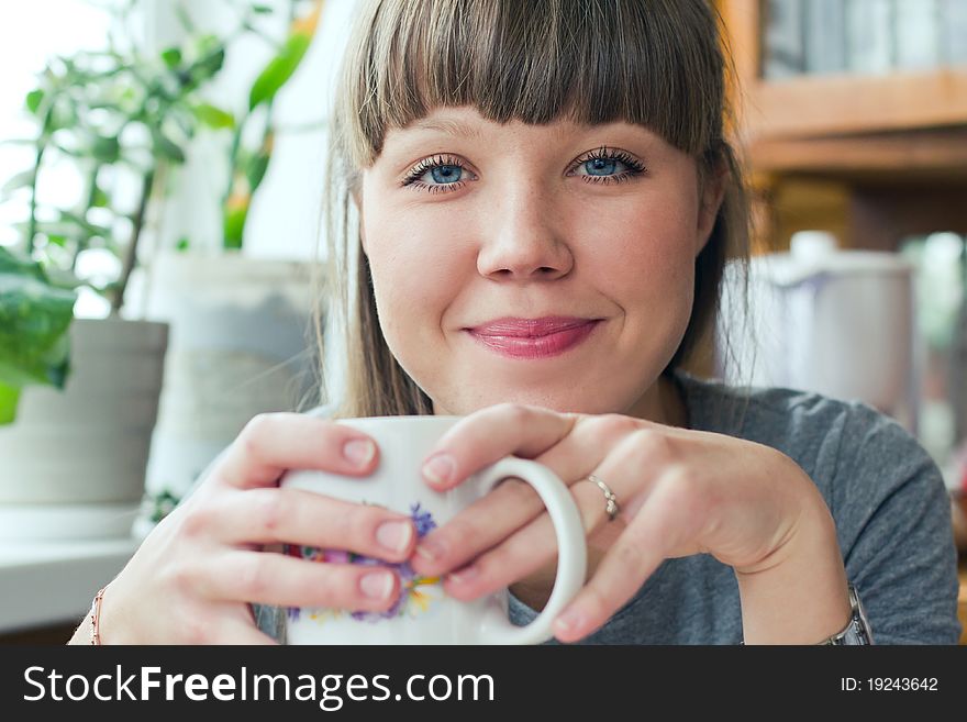 Attractive smiling girl with a cup of tea