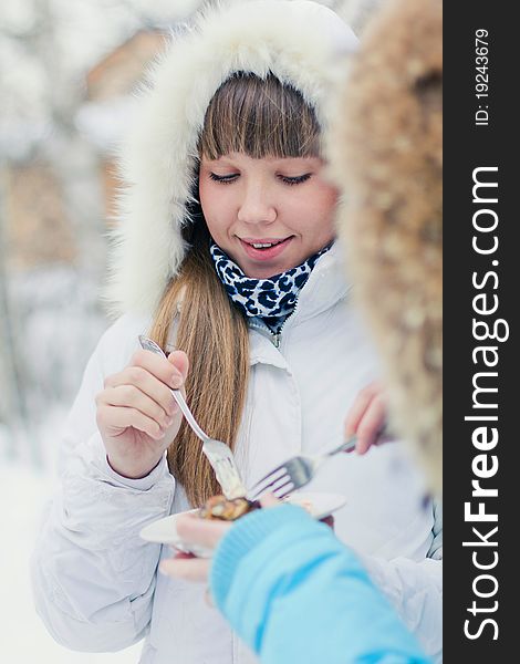 Beutiful russian girl in winter eating meat outside. Beutiful russian girl in winter eating meat outside