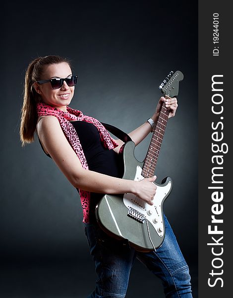 Girl wearing leather jacket with a guitar