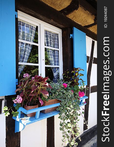 Blue window in old country cottage in Alsace, France, Europe