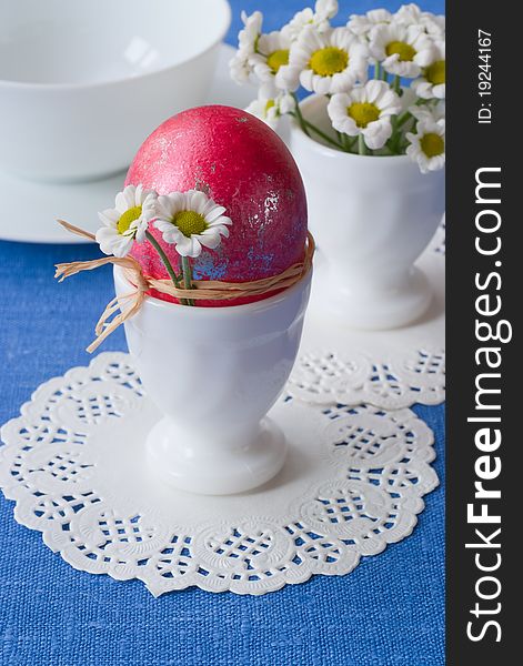 Easter egg is decorated with flowers in white eggcup, selective focus. Easter egg is decorated with flowers in white eggcup, selective focus.