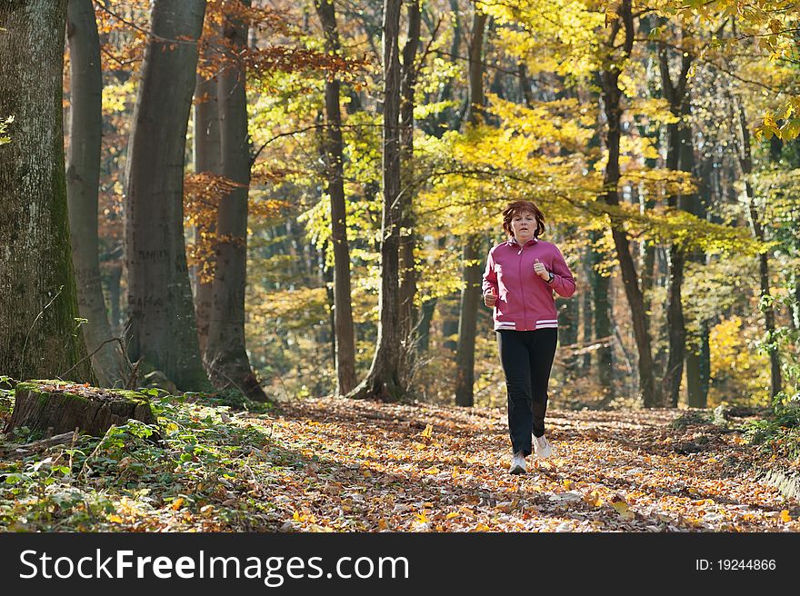 Middle age woman jogging in the forest