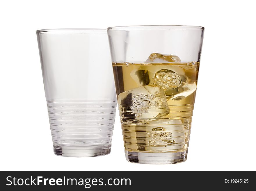 Golden whisky in a glass next to an empty glass isolated on a white background.