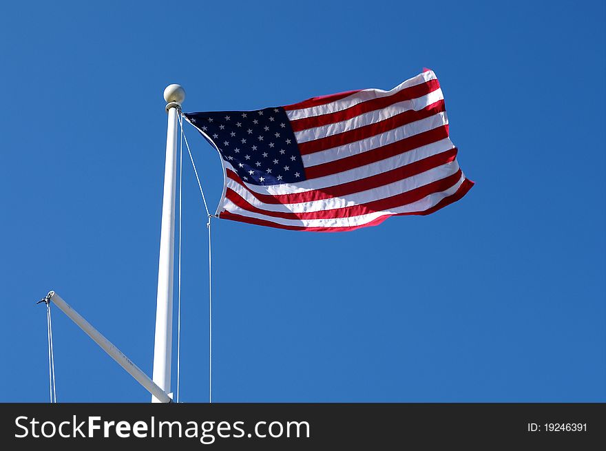 American Flag on a Pole Waving in the Blue Sky. American Flag on a Pole Waving in the Blue Sky