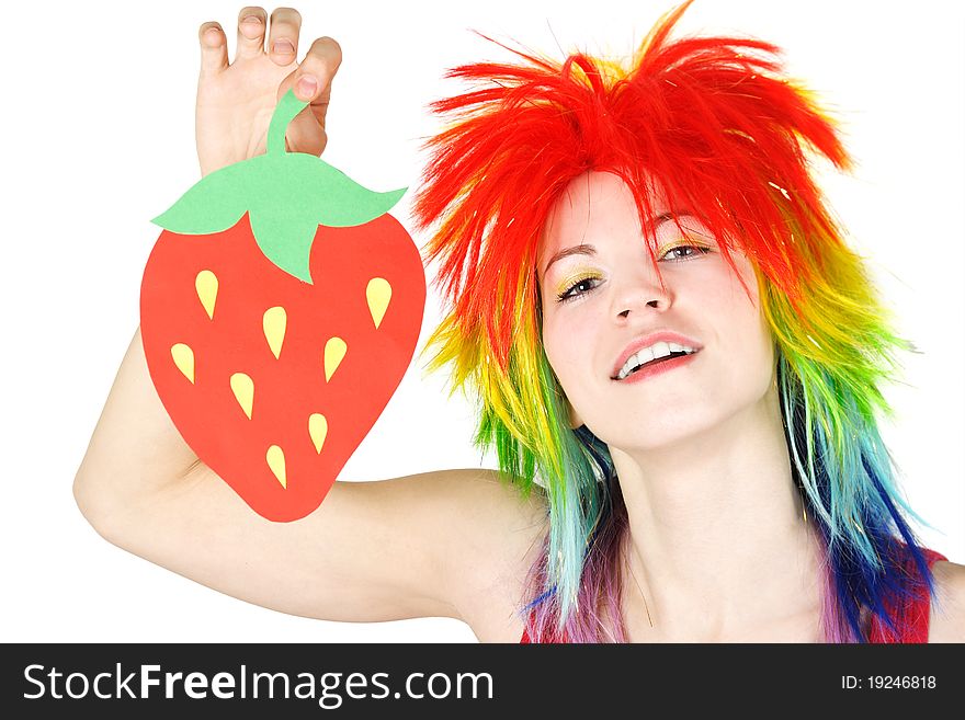 Young beauty woman in multicolored clown wig smiling and holding strawberry cardboard, isolated. Young beauty woman in multicolored clown wig smiling and holding strawberry cardboard, isolated