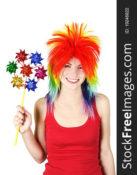 Young beauty woman in multicolored clown wig smiling and holding pinwheel, isolated. Young beauty woman in multicolored clown wig smiling and holding pinwheel, isolated