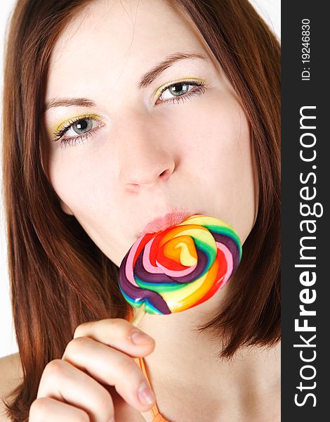 Closeup of young brunette girl eating big multicolored lollipop. Closeup of young brunette girl eating big multicolored lollipop