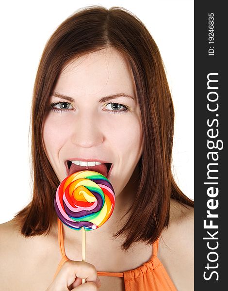 Young brunette girl licking big multicolored lollipop, isolated. Young brunette girl licking big multicolored lollipop, isolated