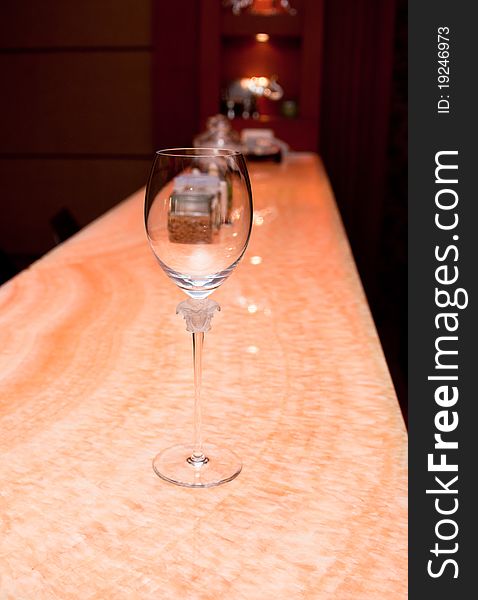 A designer crystal wine glass on a bar. A designer crystal wine glass on a bar