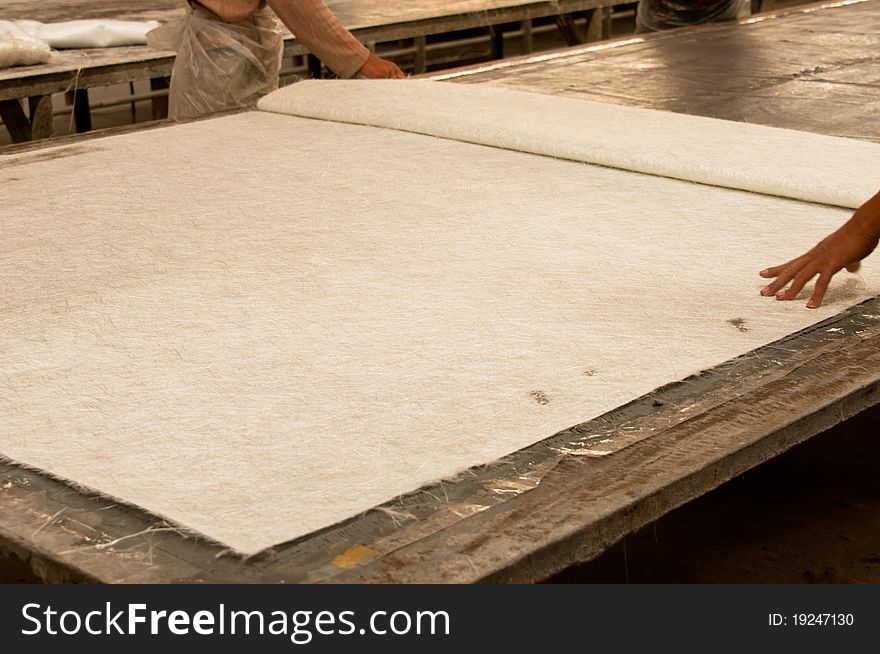 Worker unfolding a sheet of fiber glass in factory. Worker unfolding a sheet of fiber glass in factory