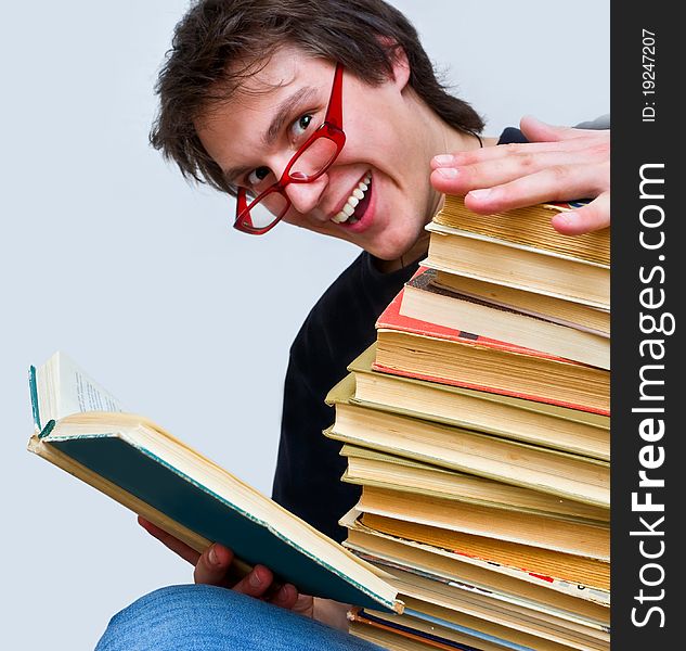 Student happily smiles opening one of his textbooks. Student happily smiles opening one of his textbooks