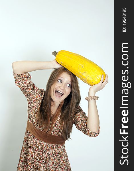 The charming girl keeps the large vegetable marrow on white background. The charming girl keeps the large vegetable marrow on white background