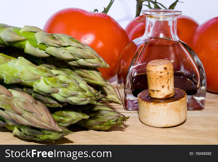 Closeup of cork, little bottle, green asparagus, red tomato. Closeup of cork, little bottle, green asparagus, red tomato