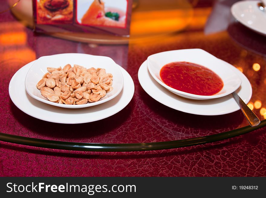 A peanut snack and a chili sauce at Asian restaurant. A peanut snack and a chili sauce at Asian restaurant