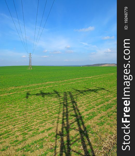 Electric power lines on green field.