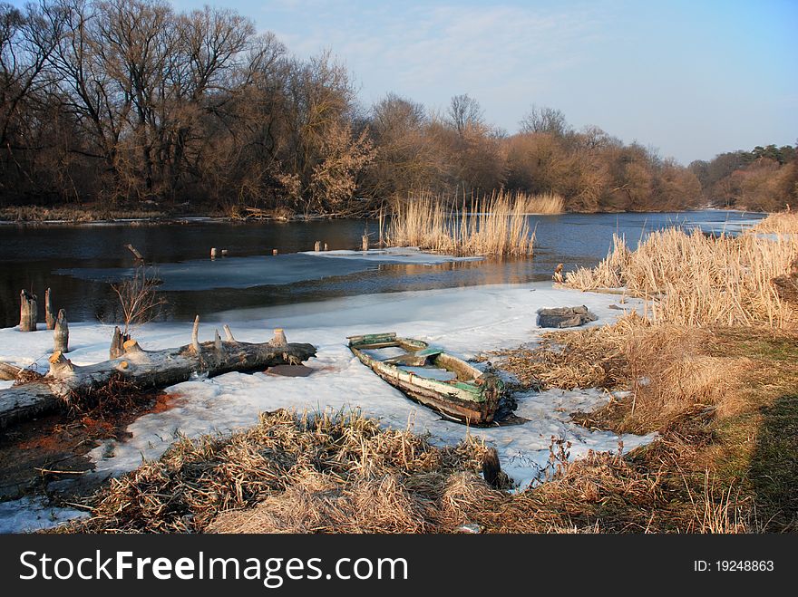 Landscape with old boat on riverside