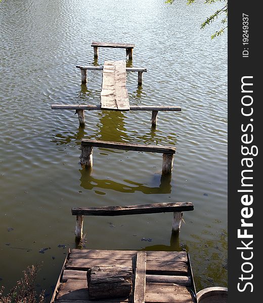 A footbridge over a rural pond. A footbridge over a rural pond.