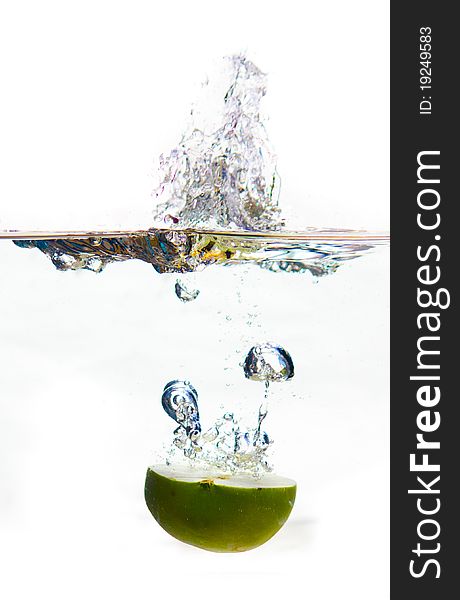 A green apple splashing to water and making bubbles while falling. A green apple splashing to water and making bubbles while falling.